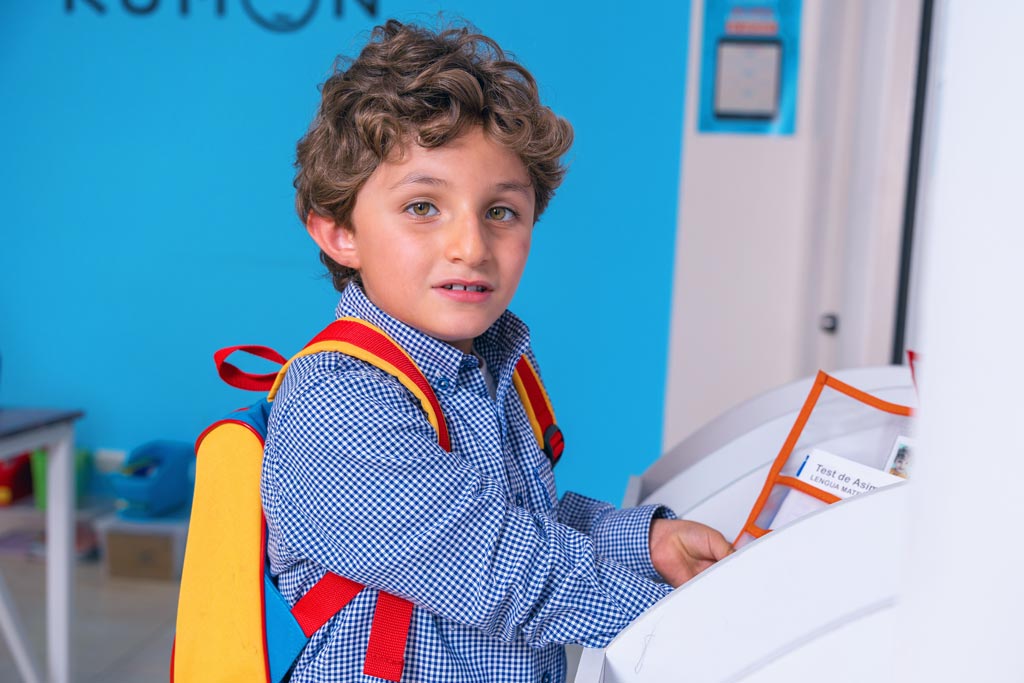 Niño entregando sus tareas en un centro Kumon, listo para continuar su aprendizaje con el método individualizado-Chile