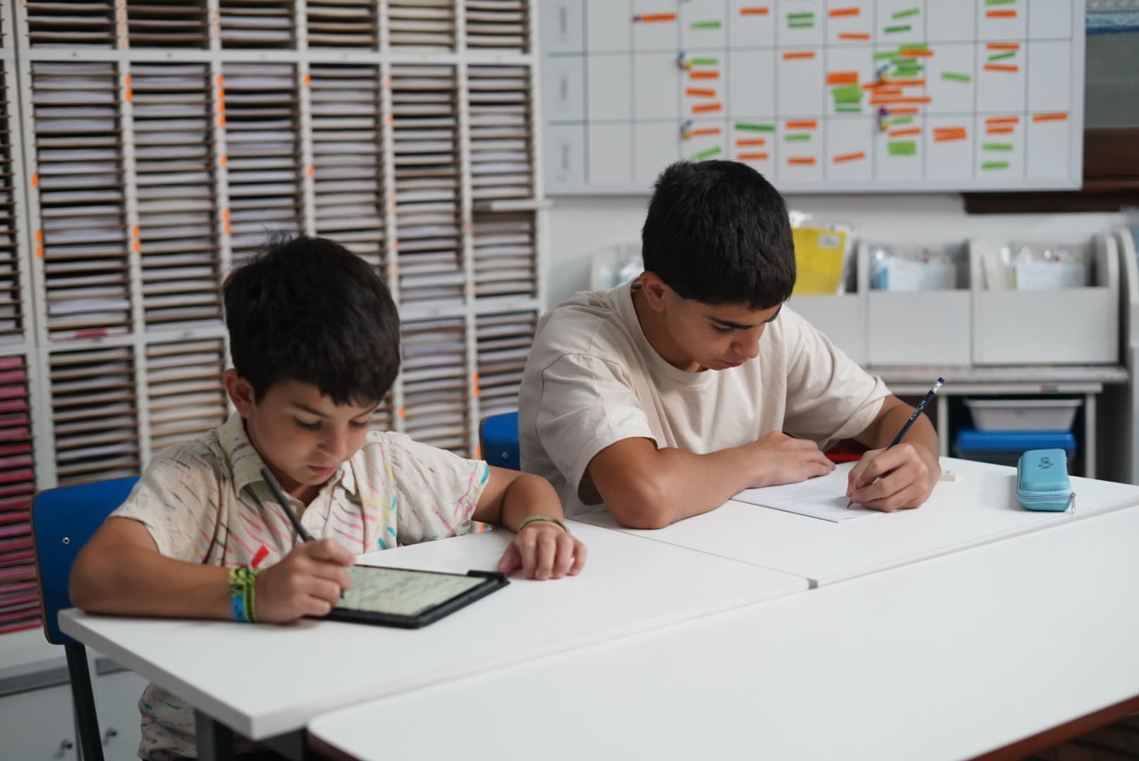 Alumnos haciendo la tarea en el material didáctico, la tablet y el cuadernillo-Chile