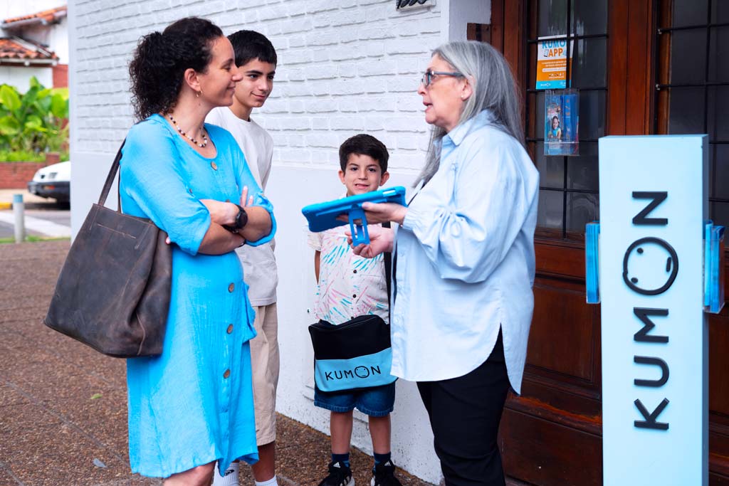 Familia conversando con una orientadora frente a un centro Kumon-Chile