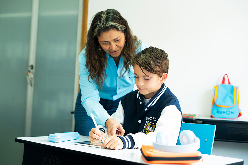 Orientadora de Kumon guiando a um alumno mientras trabaja en tableta-Chile